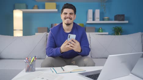 Happy-and-cheerful-young-man-looking-at-smartphone-with-focus.